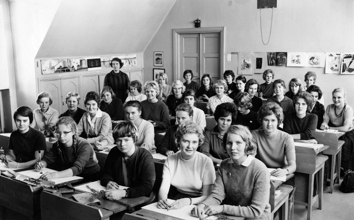 Naisoletettuja pulpeteissa vanhassa salissa.