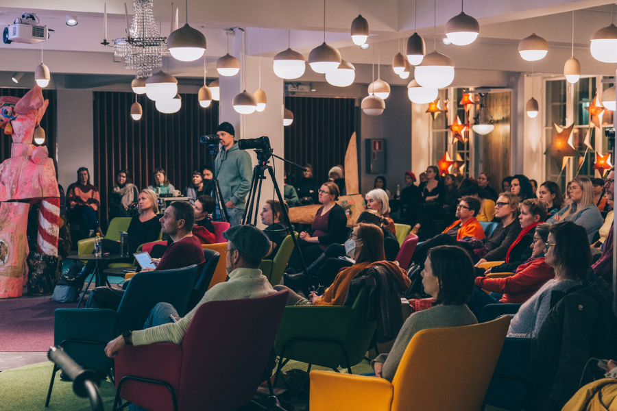 Ihmisiä yleisössä Kaupunginmuseolla seuraamassa luentoa.