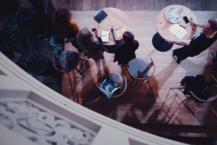 Puhe-esiintyviä ihmisiä kuvattuna yläpuolelta.