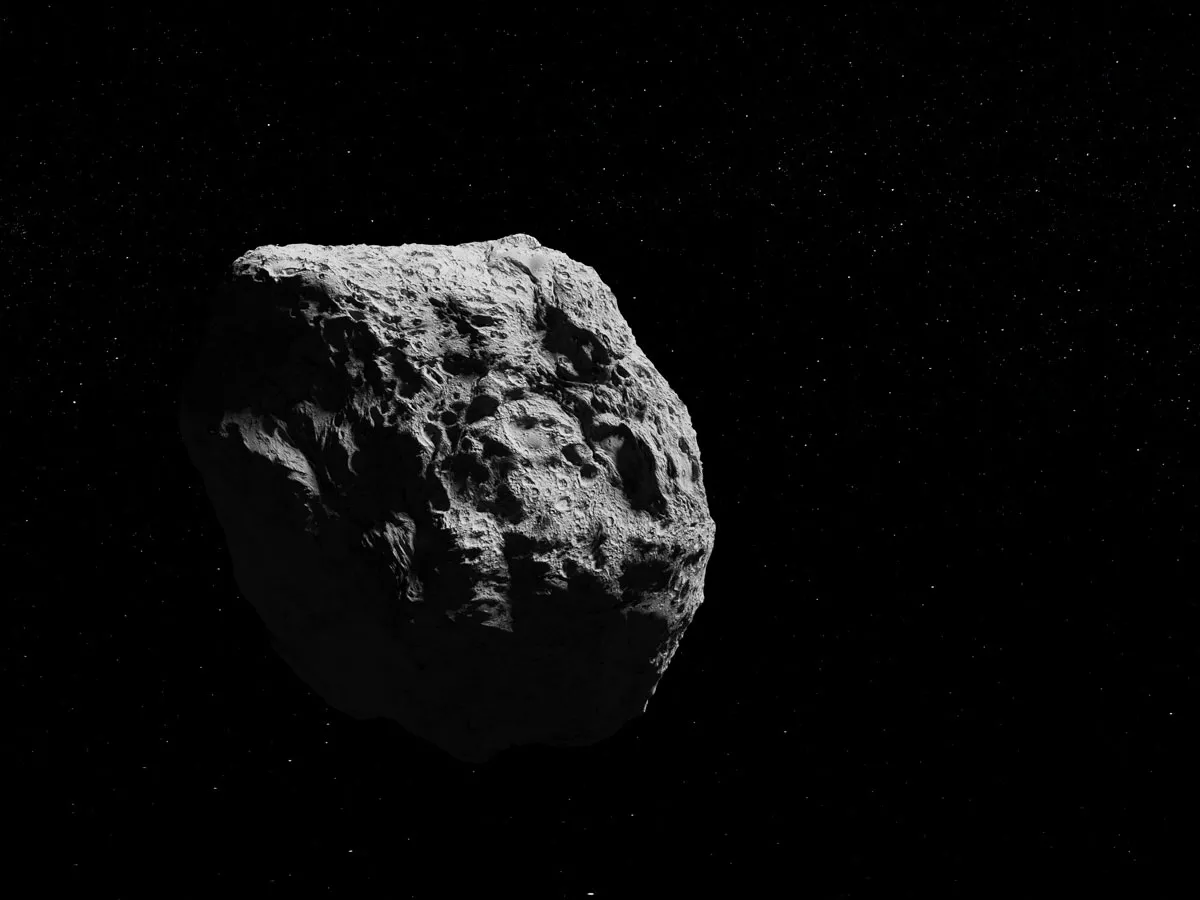 Asteroidi mustaa taustaa vasten.